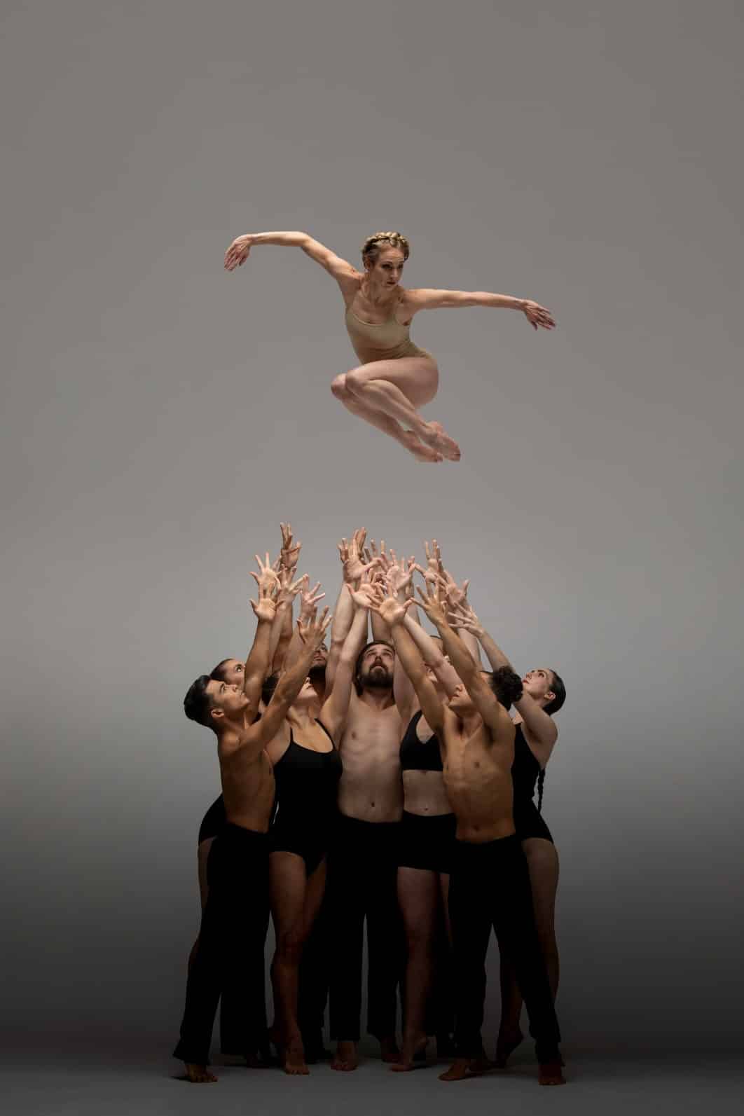 group of dancers throw up woman in air beautiful photo shoot by professional photographer in houston texas photo studio