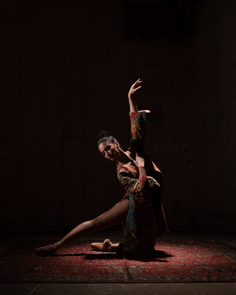 woman dancer in elegant dress dancer dark lightning on a carpet photography session in our houston texas studio by professional photographer