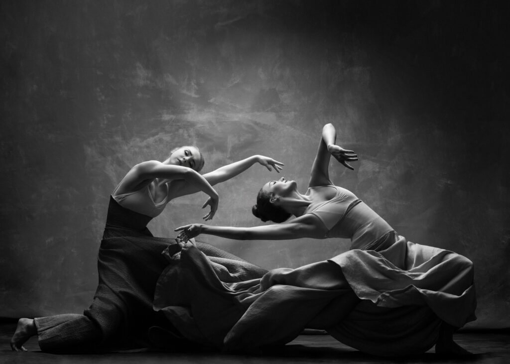 Houston dance photography, two dancers in a floor duet with flowing skirts, black and white, by Ashkan Image