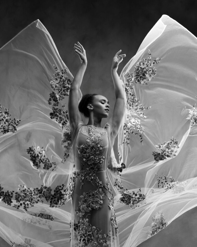 Houston dance photography, dancer with raised arms in an embroidered sheer gown, black and white, by Ashkan Image