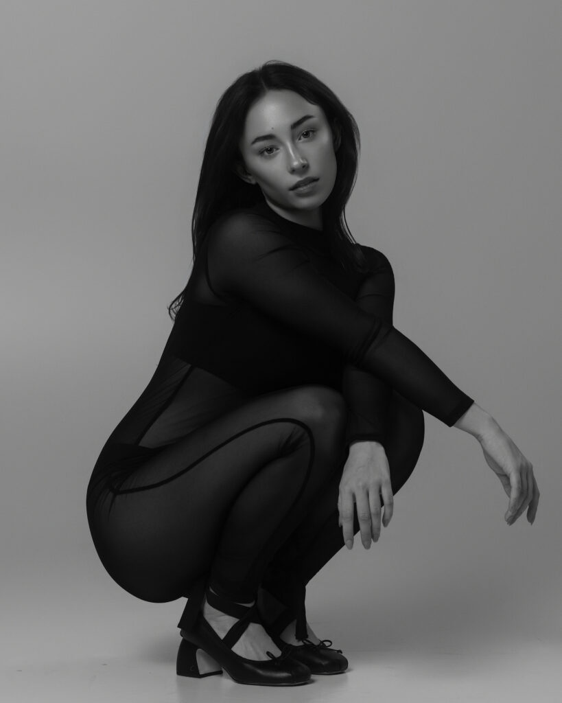Model portfolio image in black, crouching pose, Houston