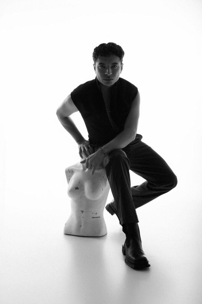 Personal branding photography in Houston, black and white portrait of a man seated on a white studio stool, by Ashkan Image