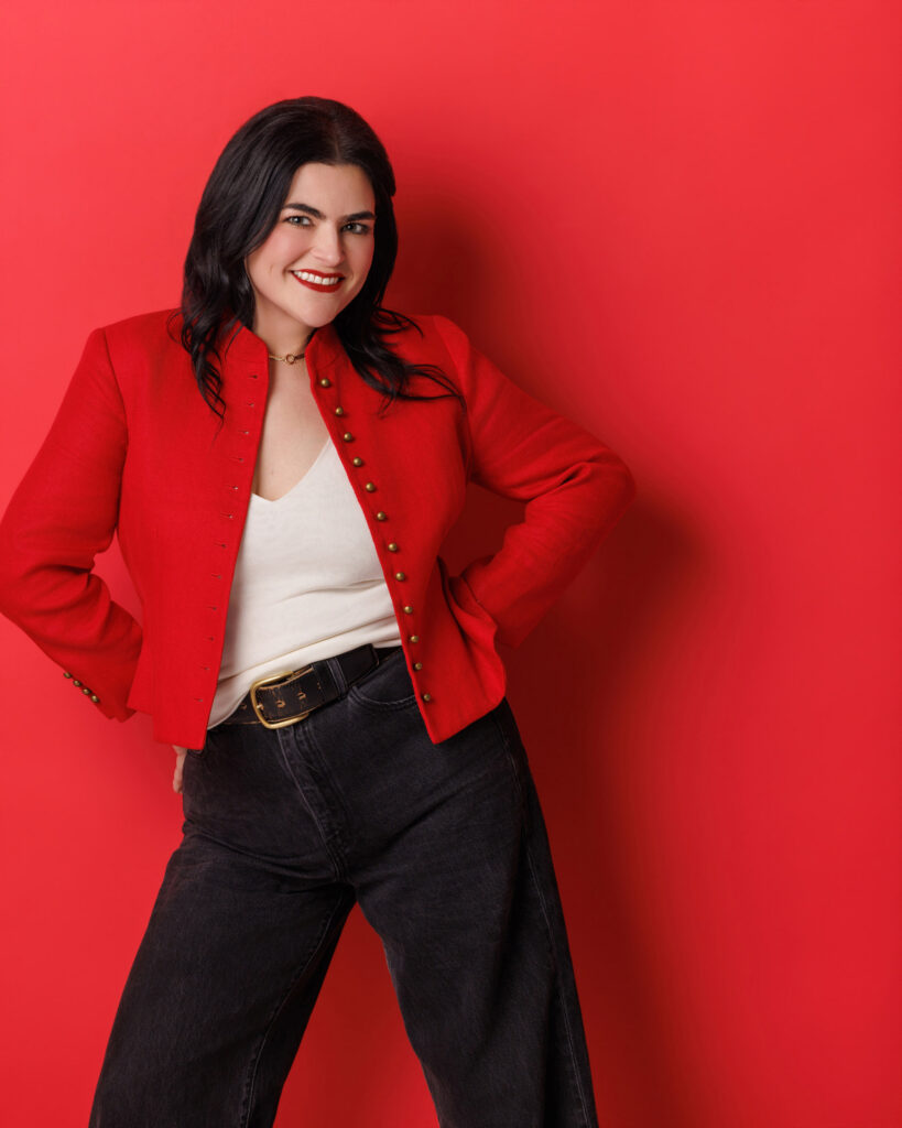 Personal branding photography in Houston, woman in a red jacket on a red backdrop, by Ashkan Image