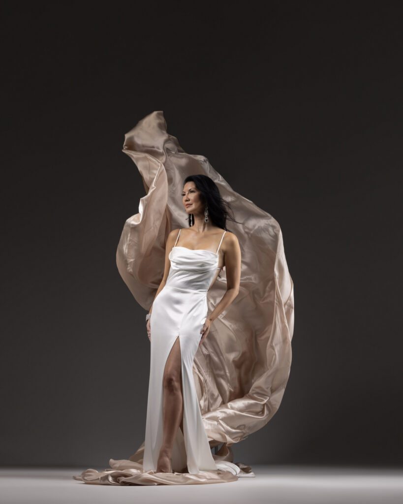 Personal branding photography in Houston, woman in a white satin gown with flowing champagne fabric, by Ashkan Image