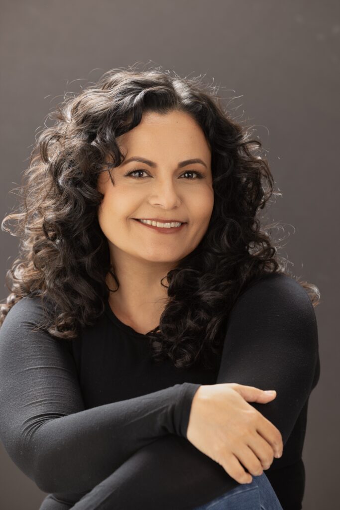 Personal branding photography in Houston, smiling woman in a black top with arms crossed, by Ashkan Image